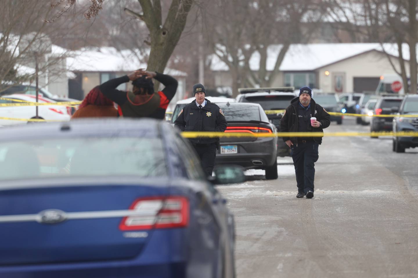 Joliet Police walk along West Acres Road at the scene were six people were found dead in two homes on Monday, Jan. 22 in Joliet.