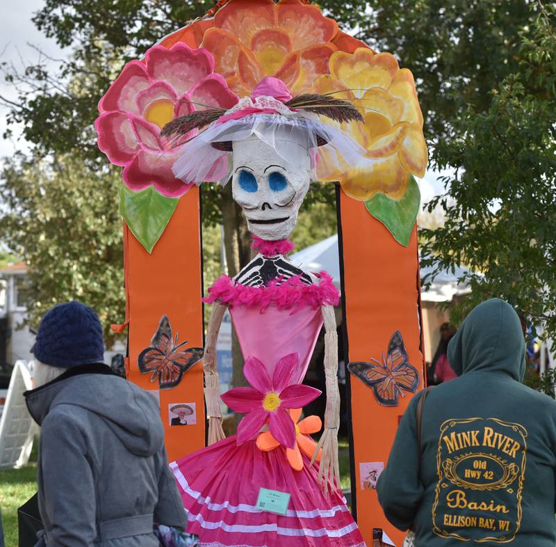 A tall, colorful scarecrow attracts attention at the Annual Scarecrow Festival in Lincoln Park in St. Charles on Friday, October 6, 2023. The event runs through the weekend with family activities and a chance to vote for your favorite scarecrow.