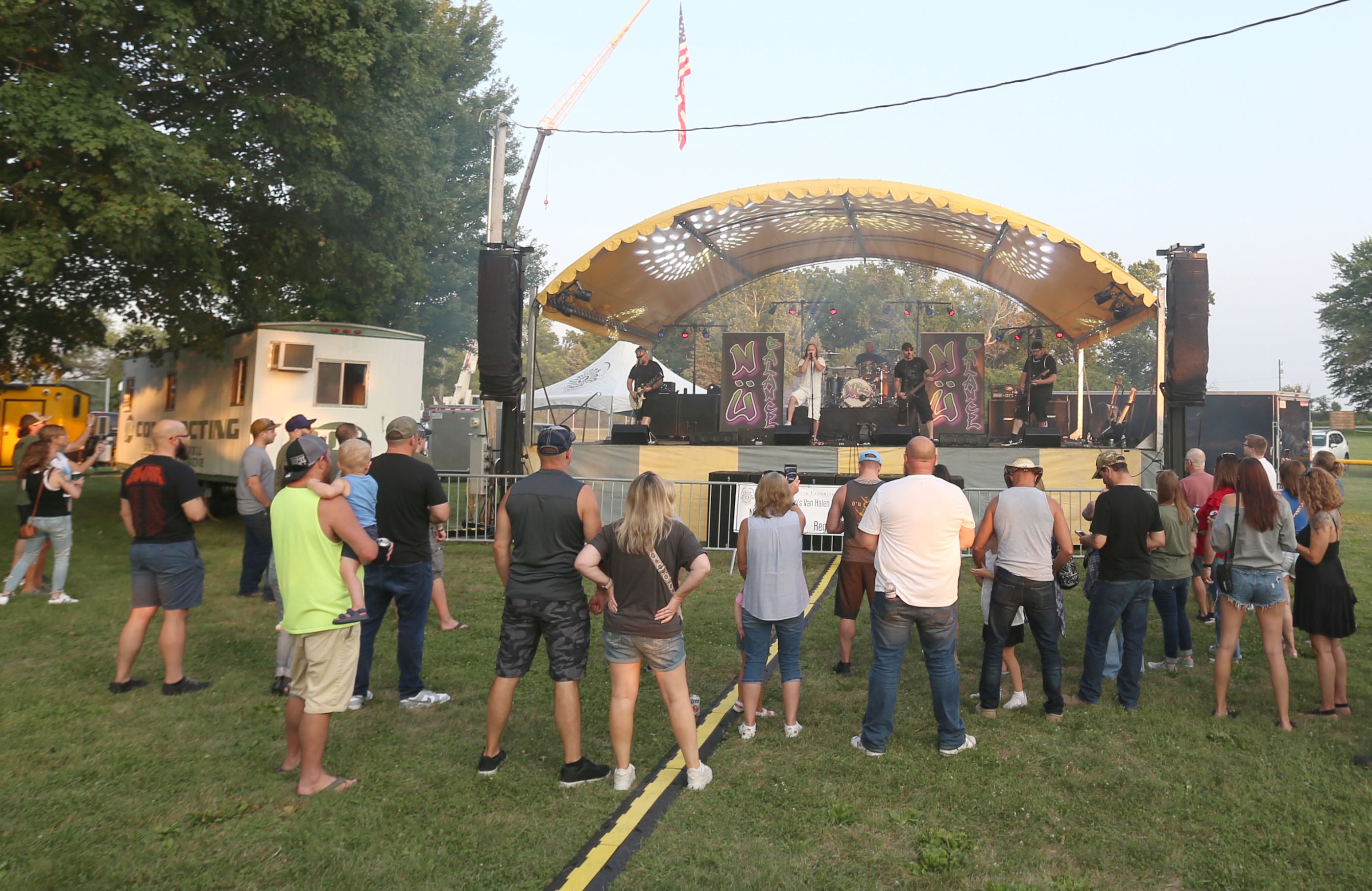 People listen to the band Nu Balance during the Cops 4 Cancer fundraiser on Friday, July 26, 2024 at Cerri Memorial Park in Cedar Point. Cops 4 Cancer began in 2003. The group helps families in their fight against cancer, by providing financial assistance in a variety of ways.