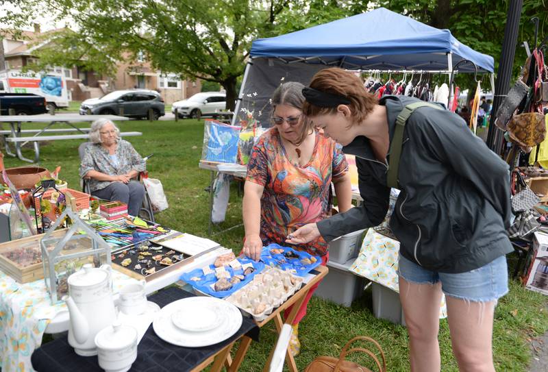 Donna Banasiewicz of Berwyn shows Kitty Muto of Berwyn  some of her stones for sale during the Berwyn Garage Sale held Saturday July 8, 2023.