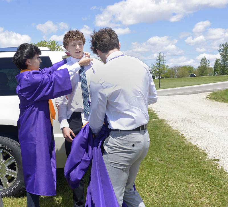 Bryan Herrera , Jace Baird and Cogan Dewey get dressed outside Mendota High School Saturday after arriving for their graduation ceremony.