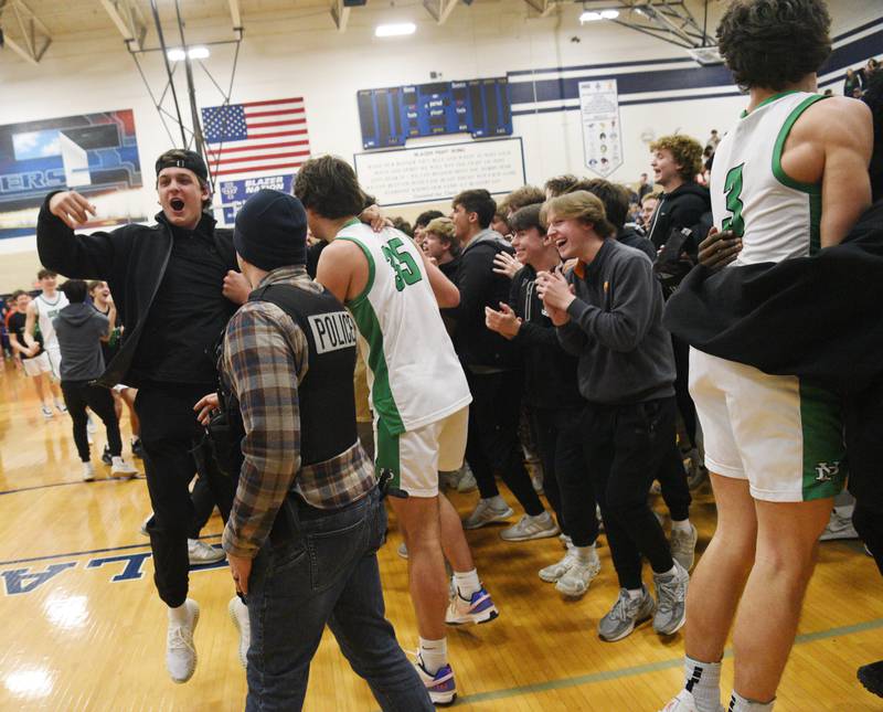 York fans rush the court after being beckoned by team members during the Addison Trail Class 4A boys basketball sectional semifinal on Wednesday, Feb. 28, 2024 in Addison.