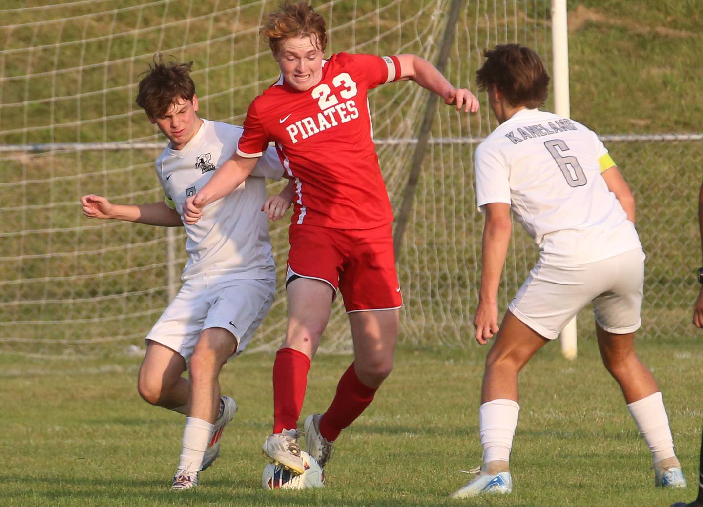 Ottawa's Evan Snook gets in between Kaneland's Cameron Guernon and teammate Noah McKittrick to kick the ball away on Wednesday, Sept. 11, 2024 at King Field.