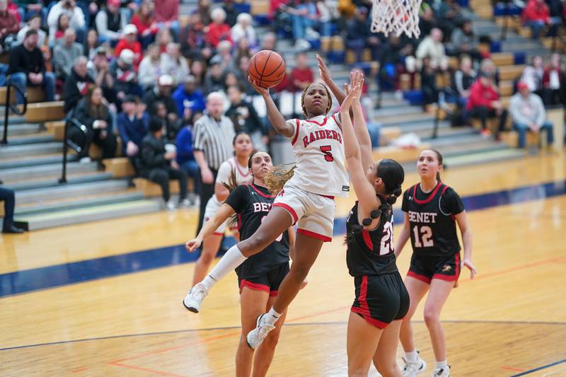 Bolingbrook's Ciyah Thomas (5) drives to the hoop against Benet’s Emma Briggs (20) during a Oswego semifinal sectional 4A basketball game at Oswego High School on Tuesday, Feb 20, 2024.