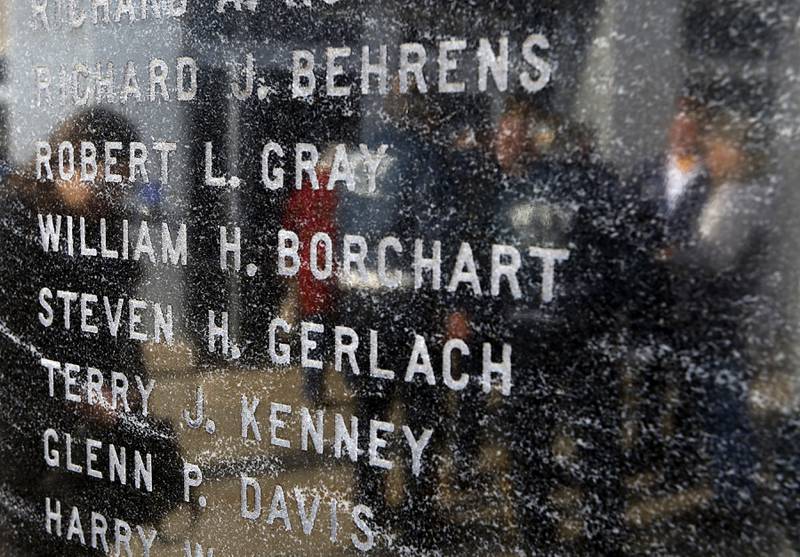 Veterans are reflected in the stone of the McHenry County Veterans Memorial bearing the names names of McHenry County veterans who died in the Vietnam War during the “Voices from Vietnam,” program on Friday, March 29, 2024, at the McHenry County Government Administration Building in Woodstock. The program was the first time that McHenry County honored Vietnam veterans on Vietnam War Veterans Day. The day, that was created by federal law enacted in 2017, honors the more than 2.7 million American men and women who served in Vietnam.