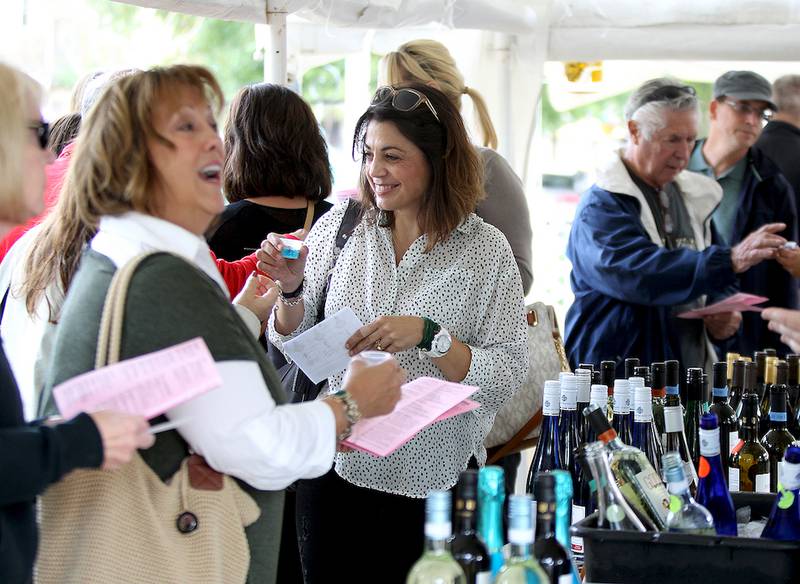 Joumana Foster (center) of Geneva tastes some of the wine available Friday during a wine tasting event at the Little Traveler as part of Festival of the Vine in downtown Geneva. The event runs through Sunday.