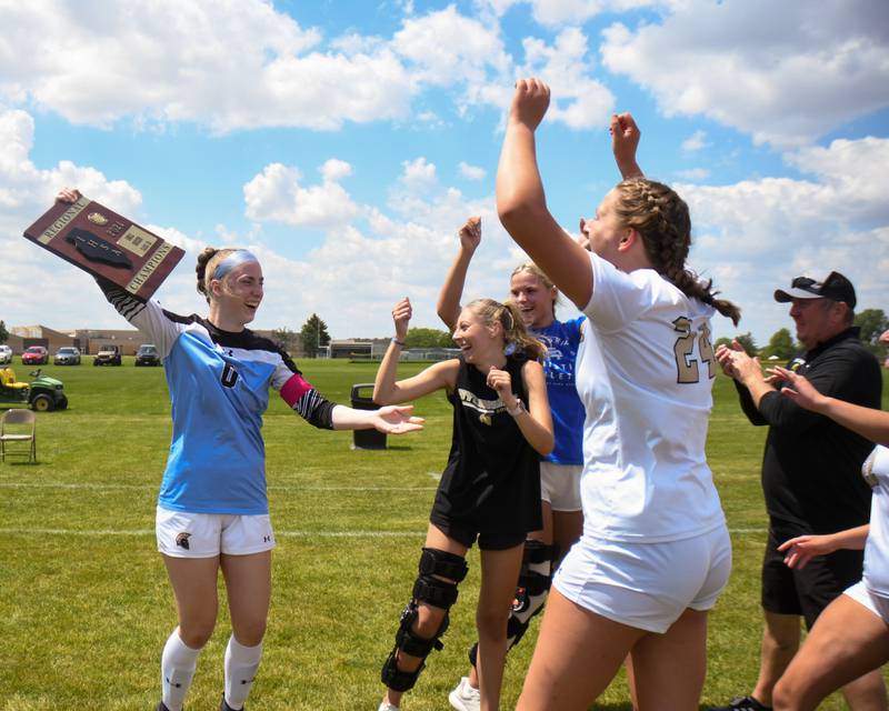 Sycamore's Tayla Brannstrom (0) raises up the regional title plaque while the team comes over to celebrate after Sycamore defeats Kaneland in penalty kicks on Saturday May 18, 2024, held at Kaneland High School.