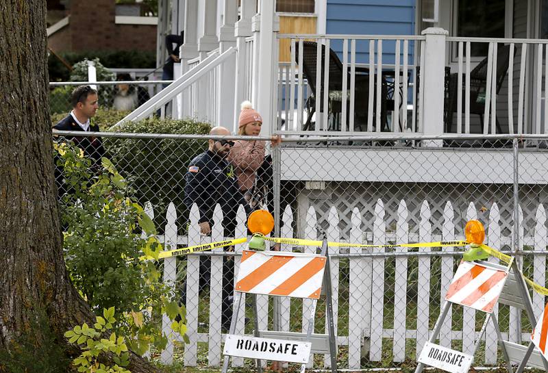 Firefighters escort Monica Diaz after she had a chance to look at the inside of her home on Tuesday, October 10, 2023, after an explosion following a gas leak in the area leveled one home as caused several fires.