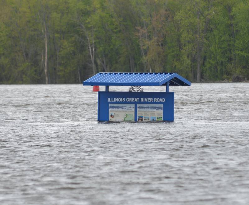 The Mississippi River continued to rise on Sunday as evidenced here by the Illinois Great River Road sign at the public boat dock in Albany.