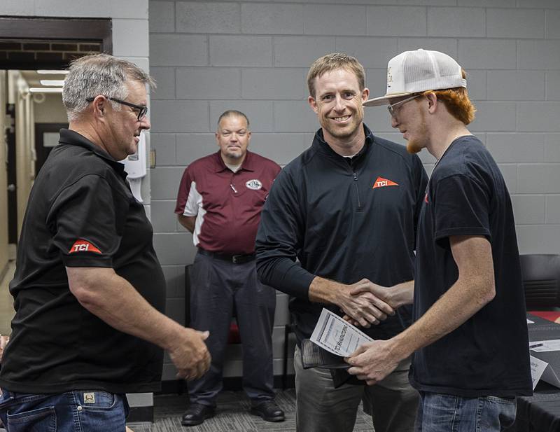 Chad Colby (left) and Patrick Reaver shake hands with TCI’s new employee Garrett Galentine of Prophetstown High School Friday, May 17, 2024. WACC held a signing day for students entering the workforce.