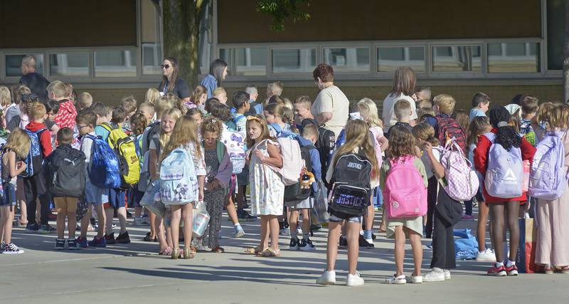 Many students gather Wednesday, Aug. 21, 2024, outside of McKinley School in Ottawa as they await the opening bell on the first day of school.