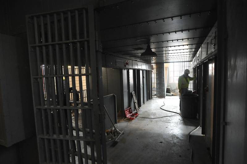 Workers with Bulley & Andrews, a Chicago-based contractor, work on removing old tables that were built into a section of jail cells in the Old Courthouse and Sheriff’s House in Woodstock on Tuesday, March 1, 2022, as the renovation of the building continues.