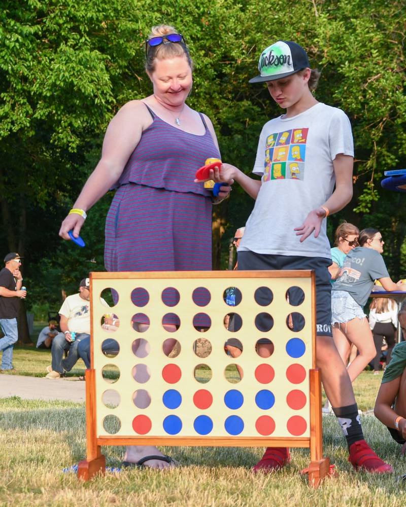 Meghan Joyner and her son Jackson, 13 years old, of Plainfield play connect four during the Summer Solstice music festival on Friday June 23, 2023 in Yorkville.