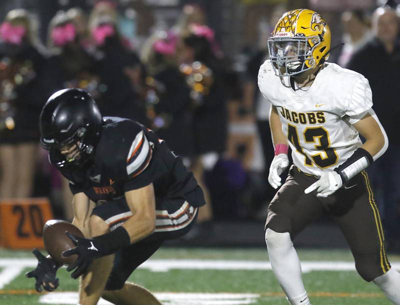 McHenry's Owen Hobson catches a tipped pass in front of Jacobs' Brandon Chvatal  during a Fox Valley Conference football game on Friday, Oct. 18, 2024, at McKracken Field in McHenry.