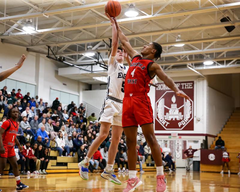 Oswego East's Mason Blanco (5) puts up a shot defended by West Aurora's Josh Pickett (4) during Class 4A Lockport Regional final game between West Aurora at Oswego East.  Feb 24, 2023.