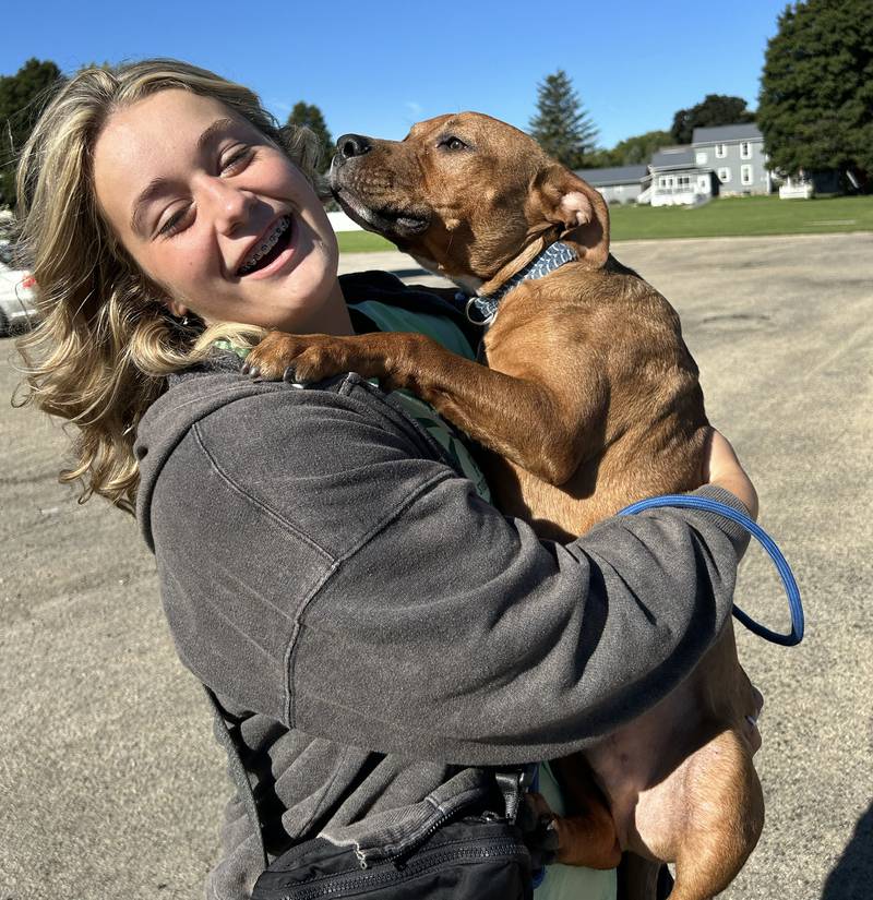 Alayna Young gets a puppy kiss from 6-month-old Charlie Brown, from  Happy Tails Animal Shelter at Polo High School's 2024 Doggy Dash on Saturday, Sept. 7, 2024. Charlie Brown was one of two shelter dogs from the Happy Tails Humane Society who attended the fundraising event.