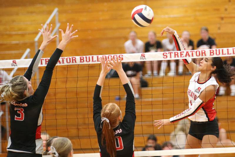 Streator's Sonia Proksa spikes the ball past Woodland's Malyna Pitte and teammate Gabby Jacobs on Monday, Aug. 26, 2024 at Streator High School.