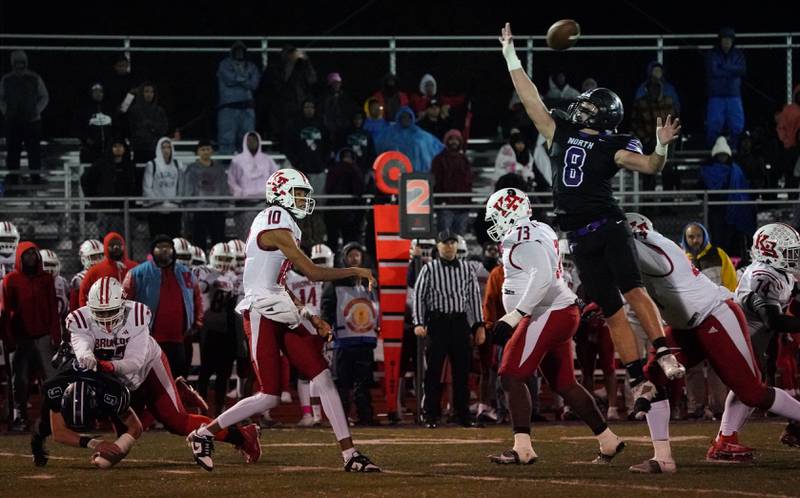 Kenwood's NaCari McFarland (10) throws a pass over Downers Grove North's Joseph Edwards (8) during a class 7A playoff football game at Downers Grove North on Friday, Oct. 27, 2023.
