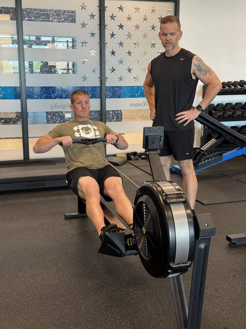 Oswego Patrol Sergeant Andy Most works out on a rowing machine as Oswego Police Chief Jason Bastin looks on. The rowing machine is part of a new fitness test for Oswego police officers.