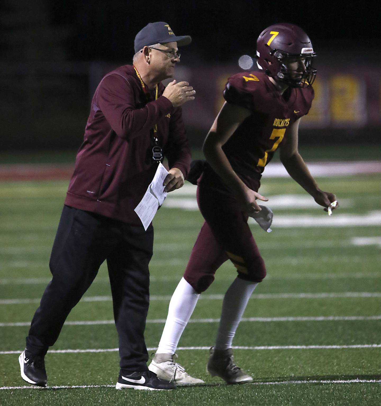 Richmond-Burton Head Coach Mike Noll gives quarterback JT Groh a play during a Kishwaukee River Conference football game against Rochelle on Friday, Oct.20, 2023, at Richmond-Burton High School.