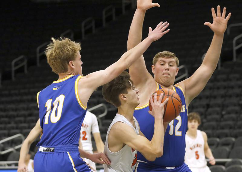 McHenry's Zachary Maness, center, drives to the basket against Johnsburg's Ben Person. left, and Jacob Welch, right, during a non-conference basketball game Sunday, Nov. 27, 2022, between Johnsburg and McHenry at Fiserv Forum in Milwaukee.