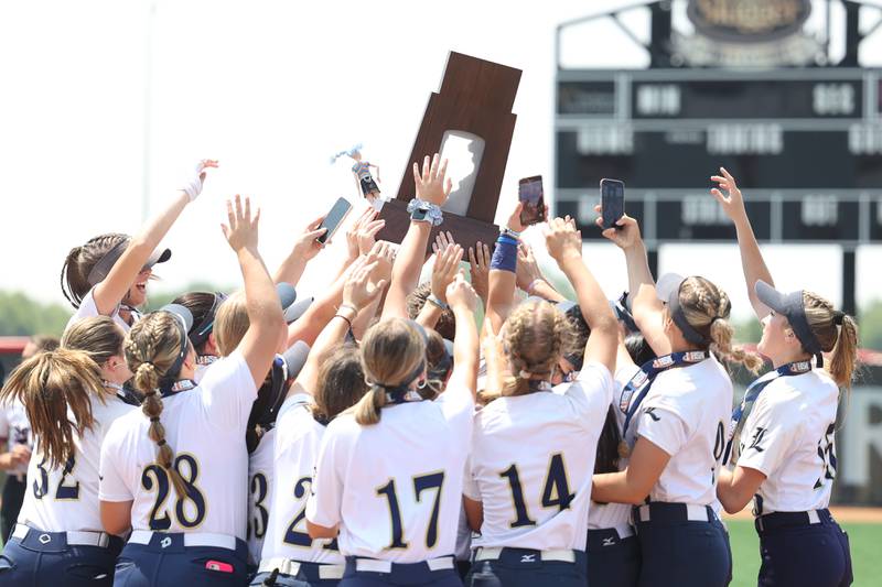 Lemont players hold up the championship trophy after their 1-0 against Antioch in the Class 3A state championship game on Saturday, June 10, 2023 in Peoria.