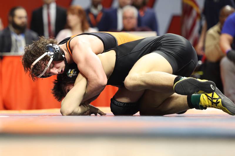 St. Charles East’s Jayden Colon works over Evan Gosz in the 144-pound Class 3A state championship match on Saturday, Feb. 17th, 2024 in Champaign.