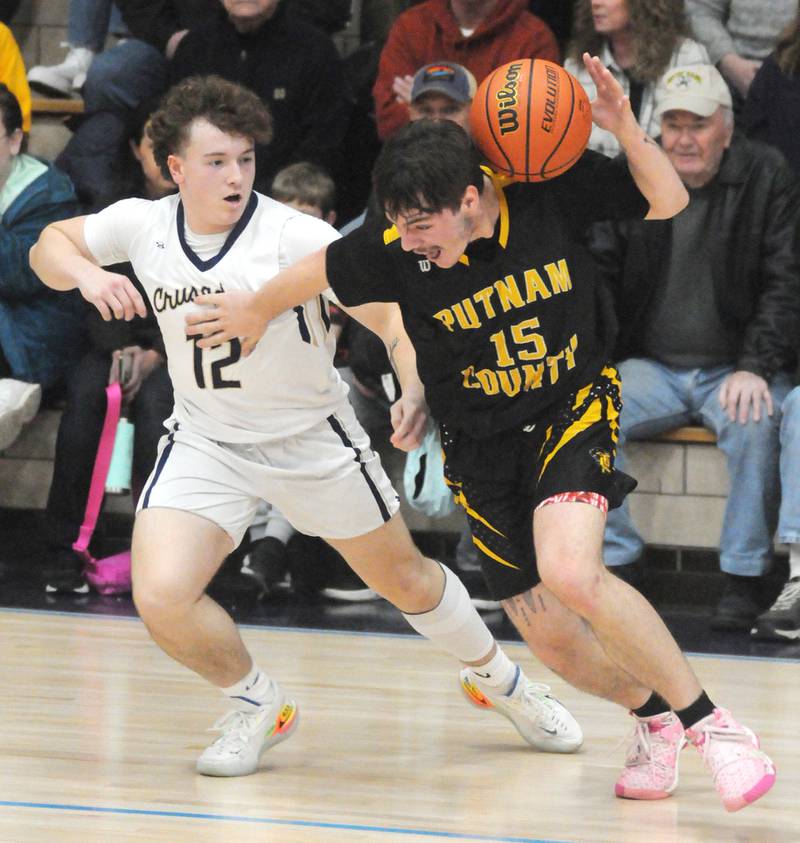 Putnam County's Spencer Voss carries the ball as Marquette's Krew Bond defends at Bader Gymnasium on Friday, Feb. 3, 2023.