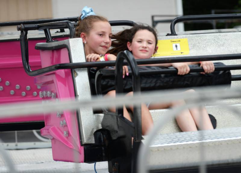 Jacey Jones, 9, and Maggie Dessing, 8, of Byron,, ride the Scrambler at the ByronFest carnival on Saturday, July 13, 2024 in Byron.