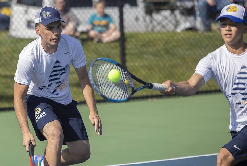 Sterling doubles player Connor Pham plays a shot in front of teammate Elias Jensen against Dixon during a tennis match Thursday, May 4, 2023.