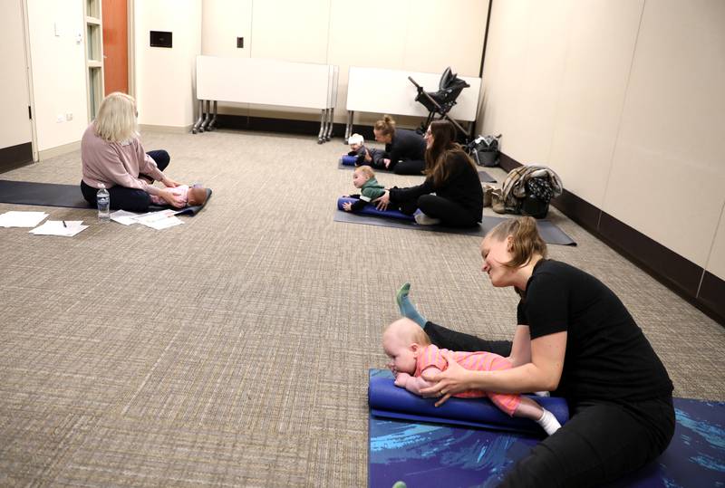 Patricia Ideran (left), a pediatric occupational therapist and certified in baby yoga and massage for Northwestern Medicine, teaches a baby yoga class with (from right) Megan Drennan of St. Charles and her daughter, Enid, 3 months, Alex Heintz of St. Charles and her son, Calvin, 7 months, and Danielle Slavinskas of St. Charles and her son, Milo, 6 months, at Northwestern Medicine Delnor Hospital in Geneva.