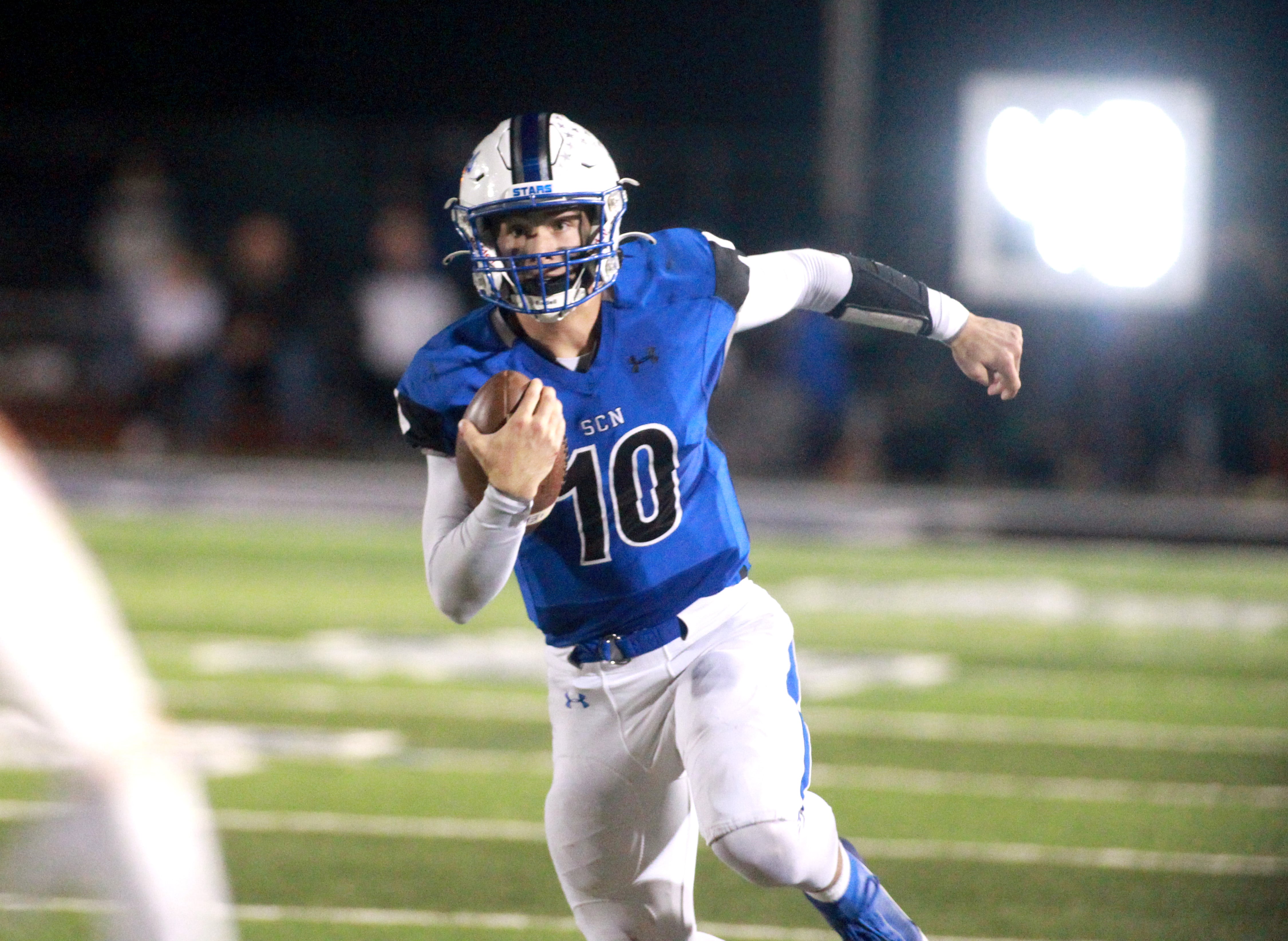 St. Charles North quarterback Ethan Plumb keeps the ball during a game against Geneva in St. Charles on Friday, Oct. 20, 2023.