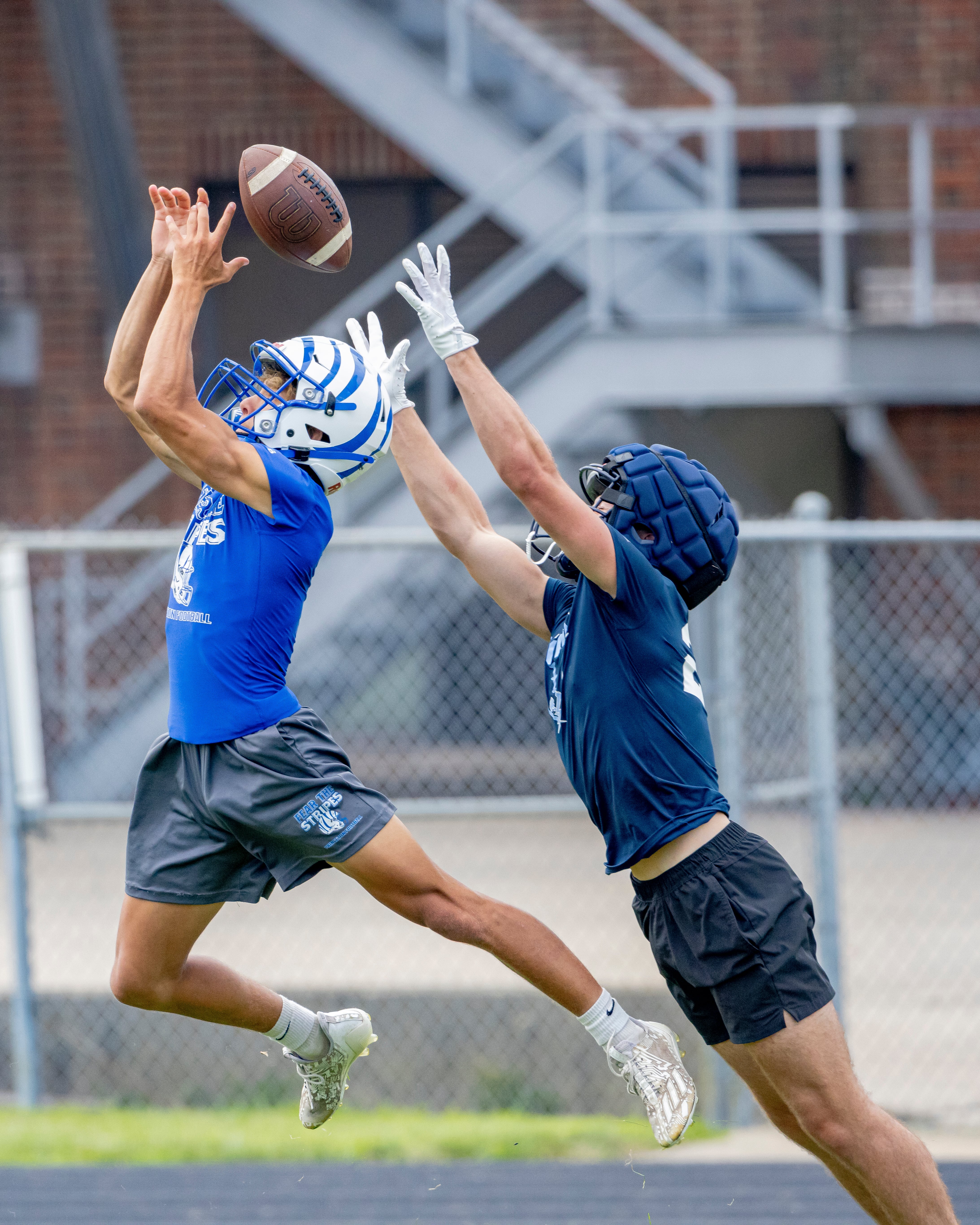 A Princeton and Bureau Valley player reach for a pass during a multiple high school practice football meet at Princeton High School on July 20, 2024.