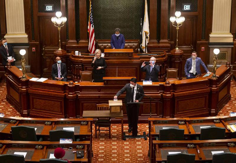 Illinois State Sen. Omar Aquino, D-Chicago, casts his ballot for Joe Biden and Kamala Harris as a member of the Illinois Electoral College as members cast ballots for president and vice president in the Illinois House Chamber at the Illinois State Capitol, Monday, Dec. 14, 2020, in Springfield, Ill. The 20 members of the Illinois Electoral College gathered in Springfield to formally cast their ballots for Joe Biden and Kamala Harris for president and vice president. (Justin L. Fowler/The State Journal-Register via AP)