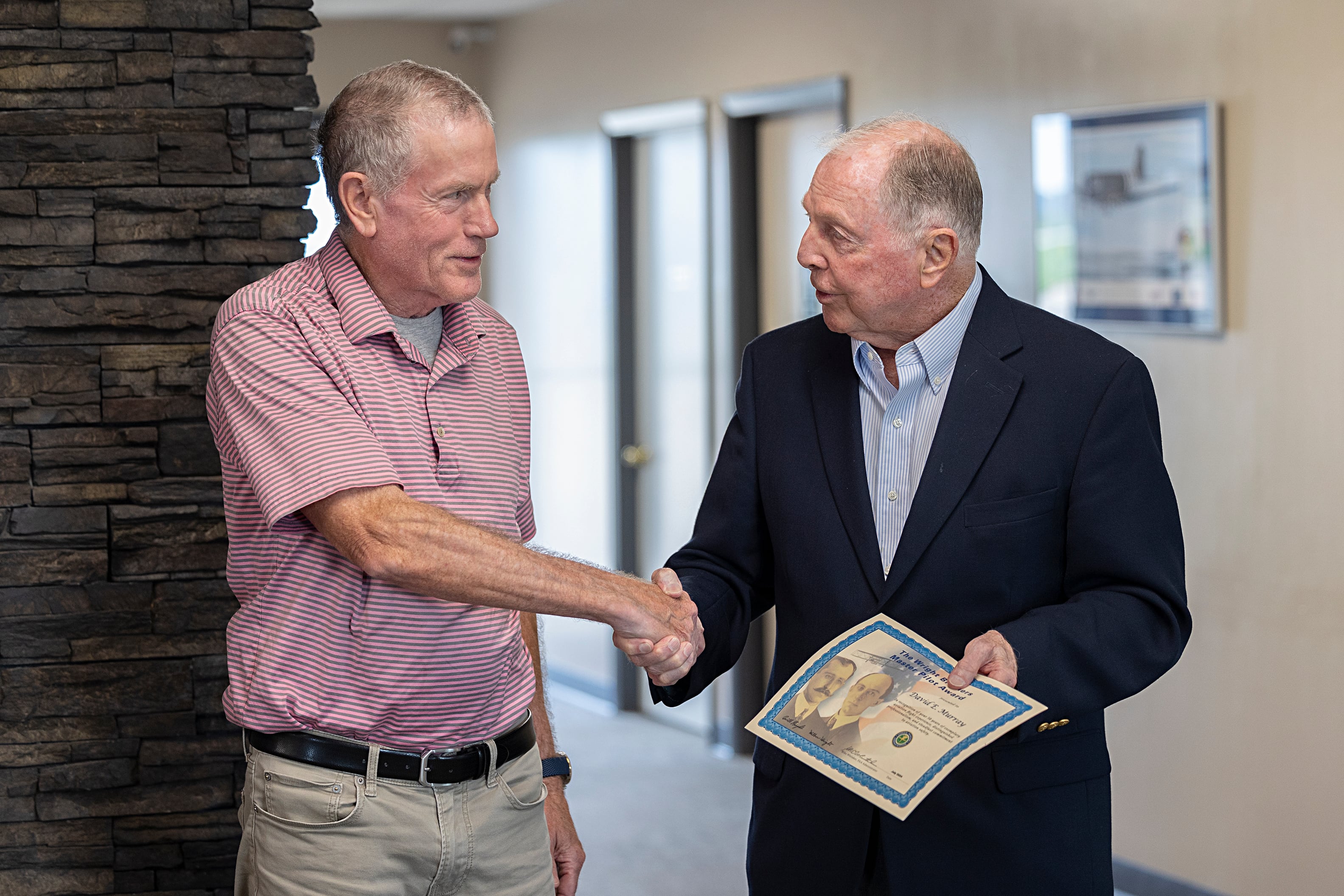 Whiteside County Airport Board president Monte Van Kooten (left) shakes the had of Dave Murray after awarding him the Wright Brothers Master Pilot Award Thursday, Aug. 15, 2024.