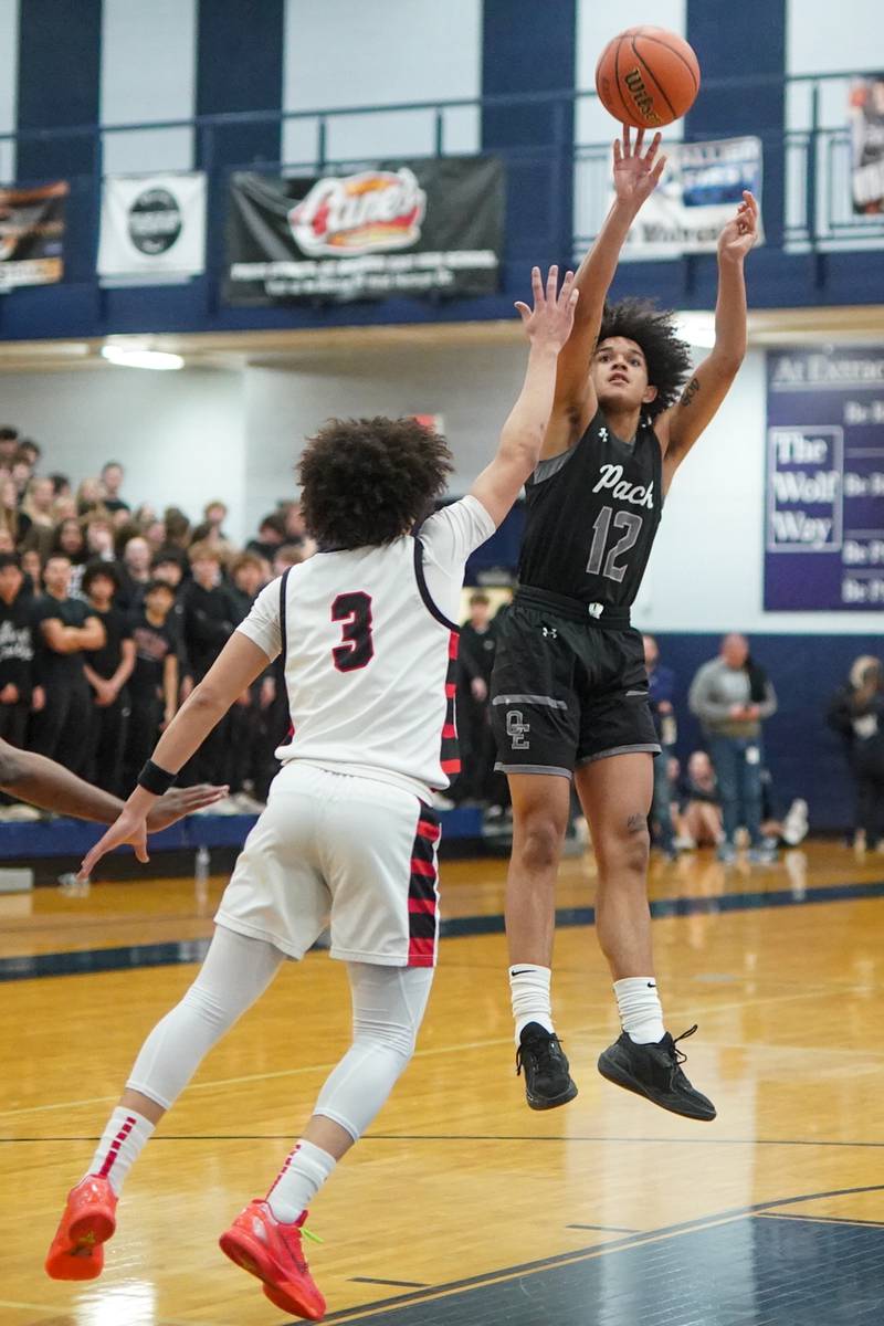 Oswego East's Drey Wisdom (12) shoots the ball over Benet’s Jayden Wright (3) during a Class 4A Oswego East regional final basketball game at Oswego East High School on Friday, Feb 23, 2024.