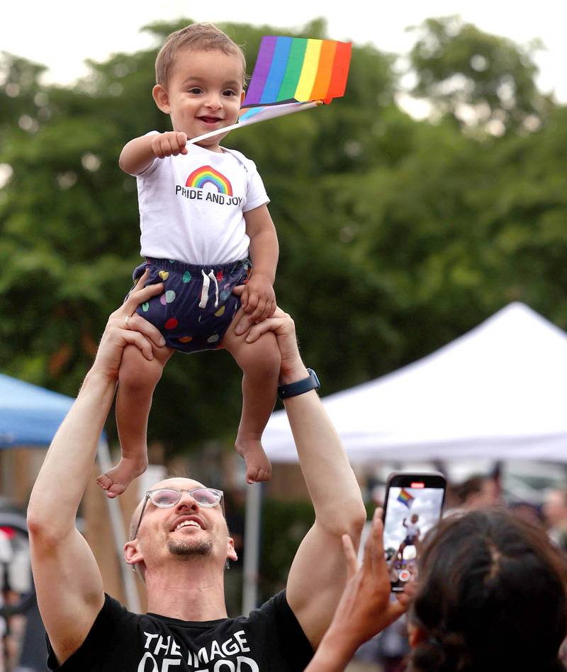 Eric Ogi, from DeKalb, holds his son Elias Singh-Ogi, 1, as his mom Shrestha Singh takes a photo Thursday, June 20, 2024, in Van Buer Plaza in front of the Egyptian Theatre during DeKalb Pride Fest.