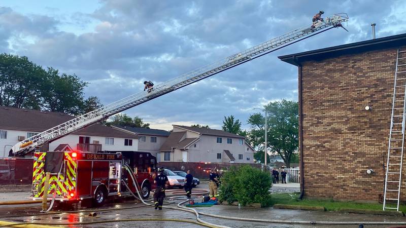 A Rochelle Fire Department ladder truck deploys its crews as firefighters work to get a blaze under control in the rear parking lot of a Husky Ridge apartment complex in the 800 block of Kimberly Drive, DeKalb, on Wednesday evening, May 29, 2024.