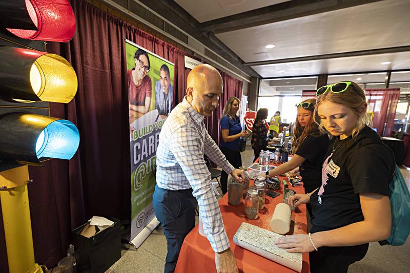 IDOT mixtures control engineer Chad Pink speaks with Challand Middle School eighth-graders Madison Stevens and Haley Janssen Friday, Oct. 20, 2023 about the different types of material used in construction.