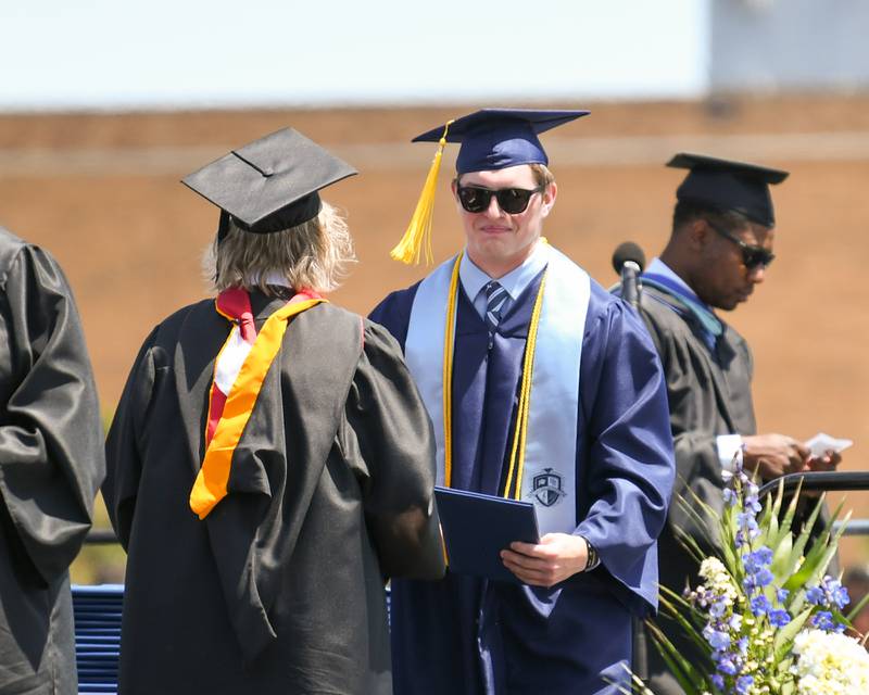 A Downers Grove South Senior is all smiles as he receives his diploma on Sunday May 19, 2024, at Downers Grove South High School.