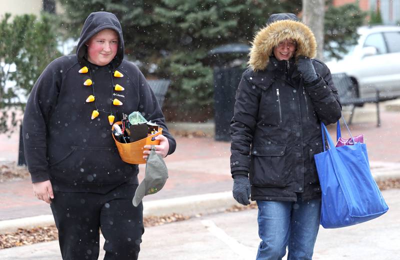 Owen Botts, of Cortland, and Colleen Rittmeyer, of DeKalb, walk through the cold in downtown DeKalb on Halloween Tuesday, Oct. 31, 2023 as the snow falls around them.