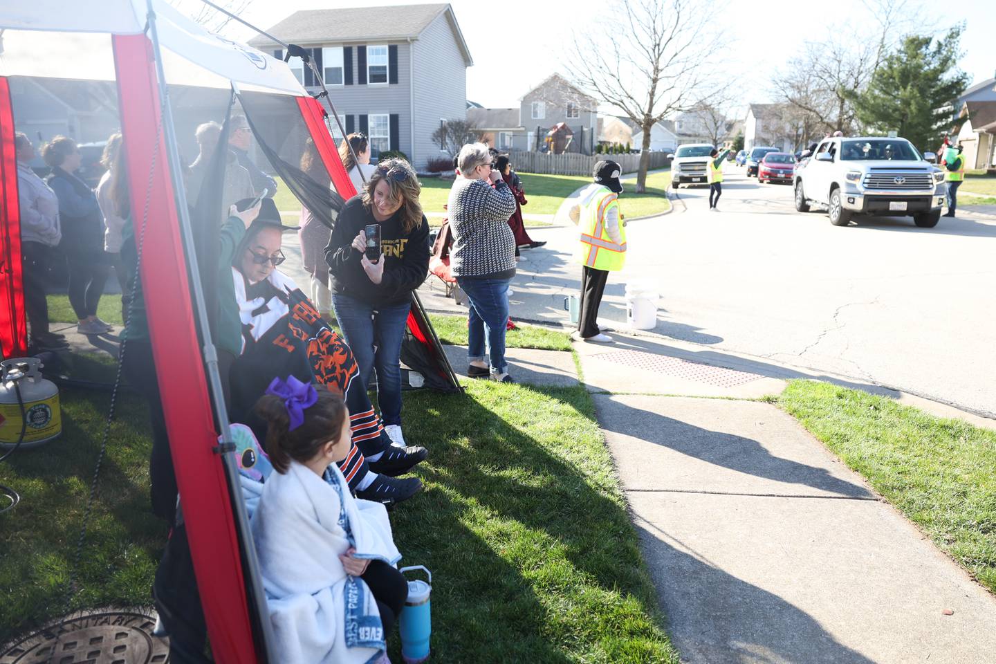 Cars drive by and wave to Tom Hernandez, left, at a drive-by parade in Tom’s honor on Saturday, March 16, 2024 in Plainfield.