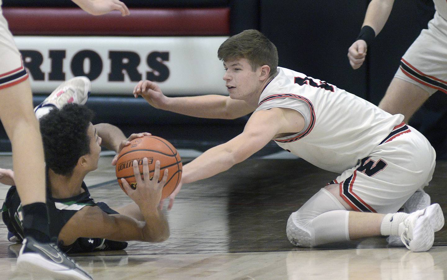 Woodland’s Jonathan Moore (2) hits the floor to fight for a loose ball with Cornerstone Christian’s Caleb Lade during Monday's regional quarterfinal at the Warrior Dome in rural Streator.