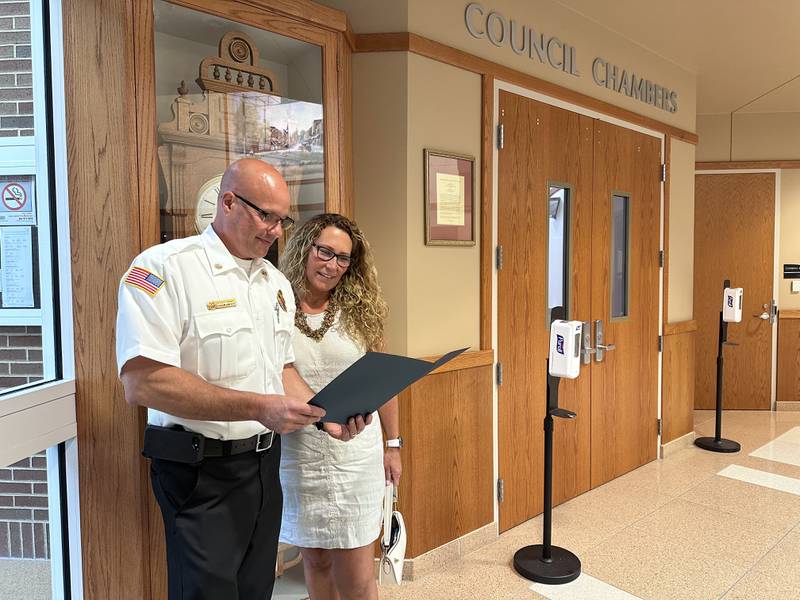 Crystal Lake Fire Rescue chief Craig Snyder shows his wife, Melissa Snyder, a copy of his oath, following his swearing in ceremony at City Hall on Friday, Aug. 4.