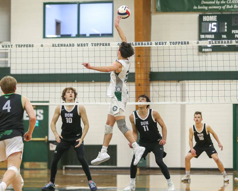 Glenbard West's Jack Anderson (6) tips the ball over the net during volleyball match between Downers Grove North at Glenbard West.  April 2, 2024.