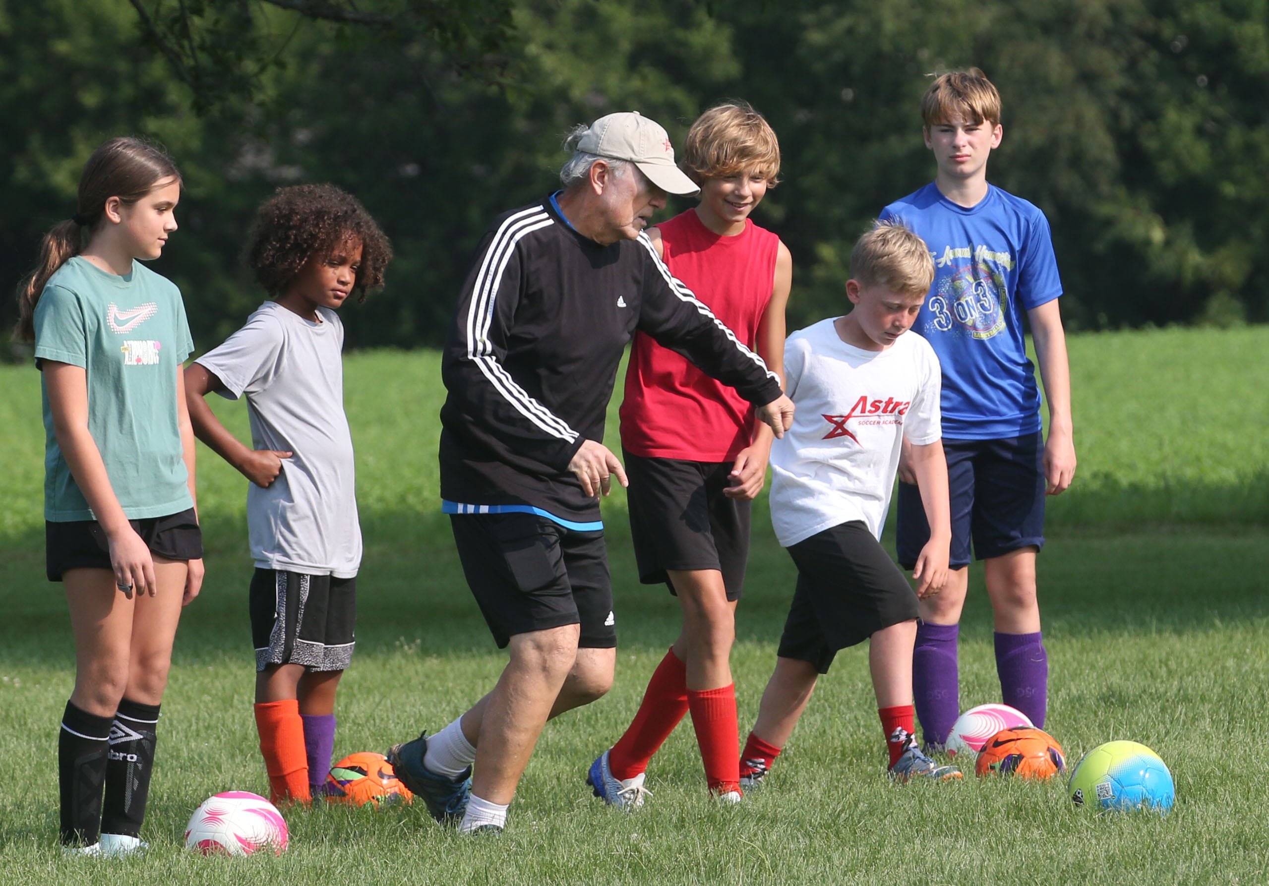 Gordan Raketic, (third from left) former professional player in Slovenia, Austria, and Spain, demonstrates drills with (from left) Cara Otley, Apollo Mencos, Jaxson DeRose, Liam Williams and Theo Bonucci during the Astra Soccer Academy free soccer clinic on Thursday, July 25, 2024 at Jefferson School in Princeton. Raketic welcomes any children in the Princeton area to participate in the free camp.