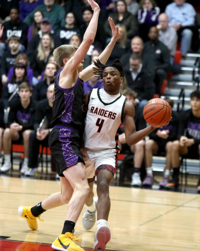 Bolingbrook’s K.J. Cathey (right) passes the ball away from Downers Grove North’s Alex Miller during the Class 4A East Aurora Boys Basketball Sectional final on Friday, March 1, 2024.