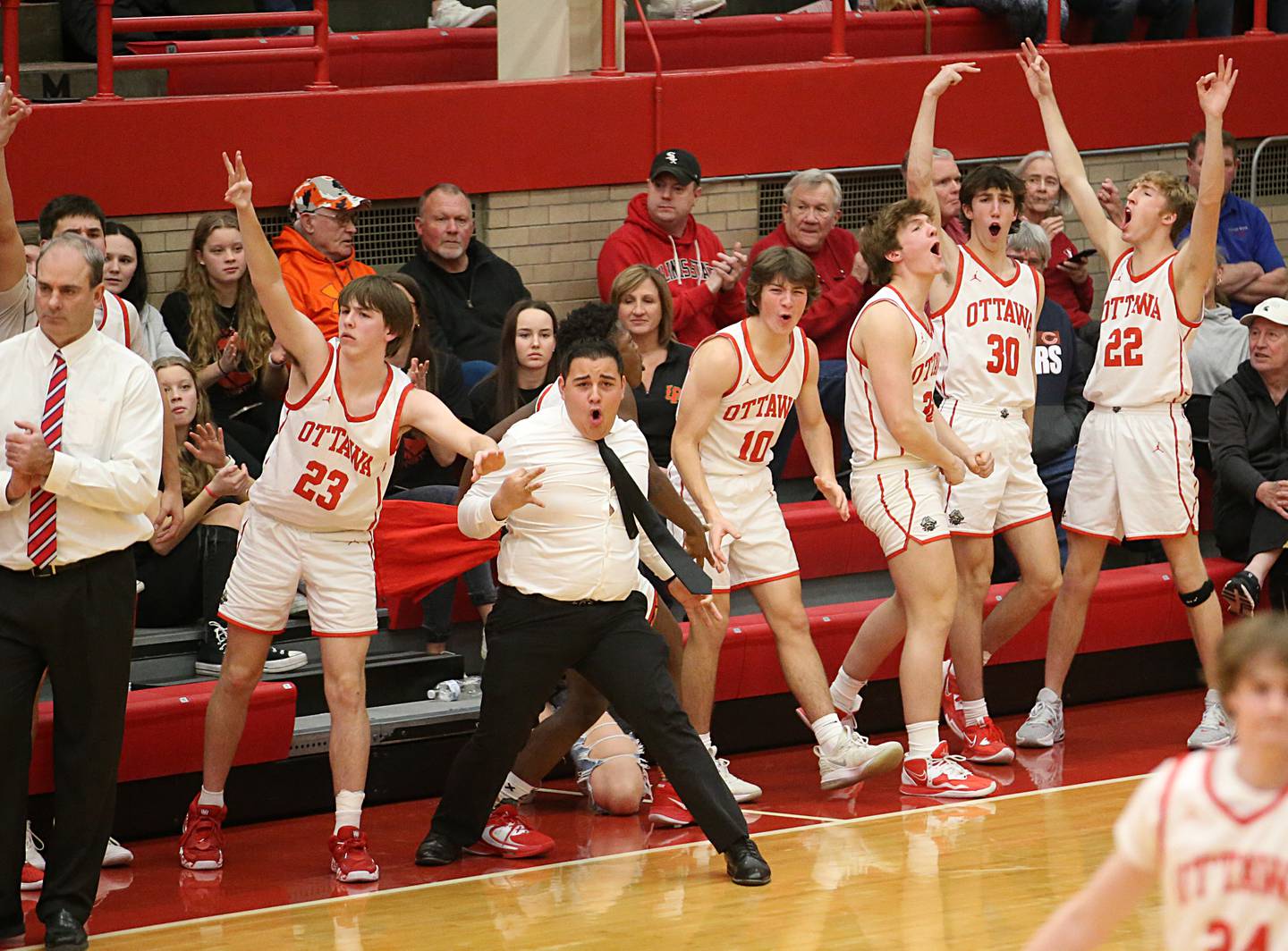 Members of the Ottawa boys basketball team react after sinking a three point basket against L-P in Kingman Gymnasium on Friday, Feb. 10, 2023 at Ottawa High School.