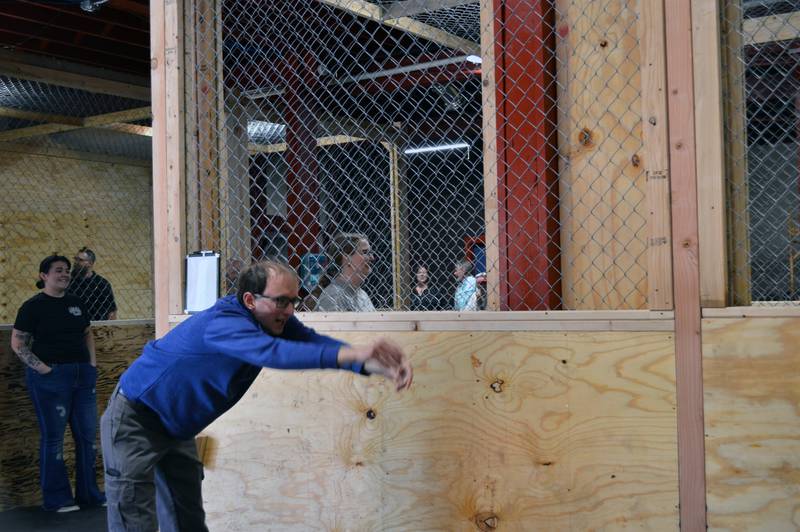 Christopher Oltmanns, of Oregon, looks up to see if the ax he threw stuck in the target. Oltmanns attended the grand opening of Rustic Ridge Axe Throwing on May 28. The business is located at 117 N. 4th St., Oregon, and is affiliated with the World Axe Throwing League.