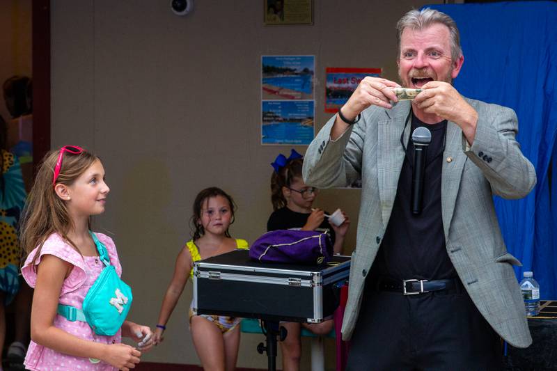 Magician Christopher George performs with the help of Macy Nowak on Tuesday, August 6, 2024 at Marseilles Swimming Pool.